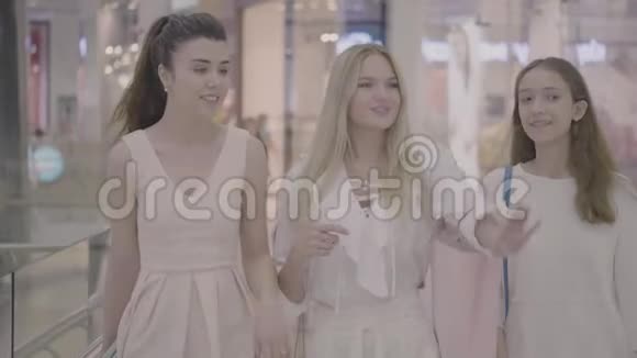 快乐的年轻女孩朋友在购物中心散步视频的预览图