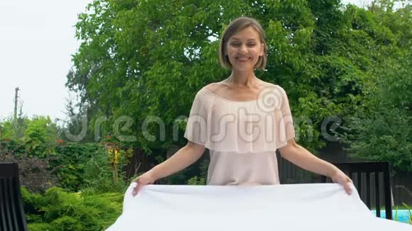 开朗的女人在户外铺白色桌布满足于洗衣粉视频的预览图