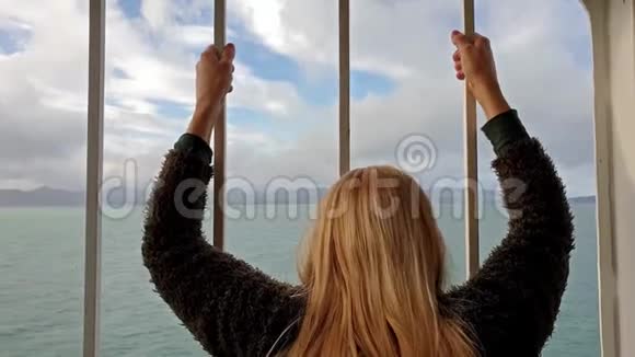 一位金发女郎拿着栏杆望着大海和陆地视频的预览图