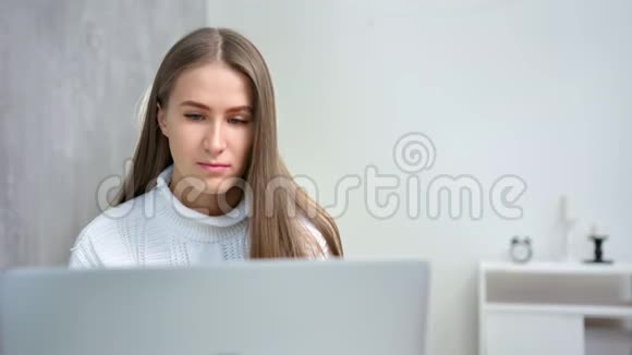 中度特写自信年轻忙碌的女性在家工作使用笔记本电脑视频的预览图