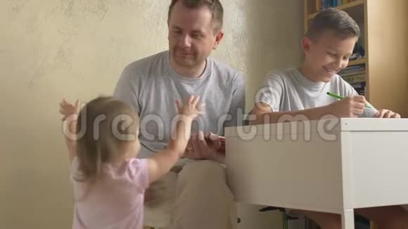 女儿来爸爸和儿子在书桌前做作业视频的预览图