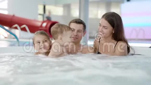 欢乐的家庭一起在按摩浴缸放松在度假胜地和孩子们玩得很开心视频的预览图