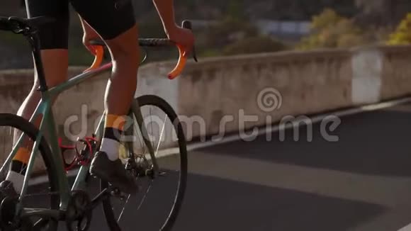 夏天骑在山路上骑自行车的人的特写镜头车轮方向盘和踏板视频的预览图