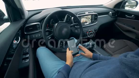 未来派自动停车场汽车自动移动一个男人在里面操作电话视频的预览图