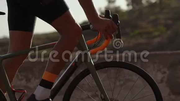 夏天骑在山路上骑自行车的人的特写镜头车轮方向盘和踏板视频的预览图
