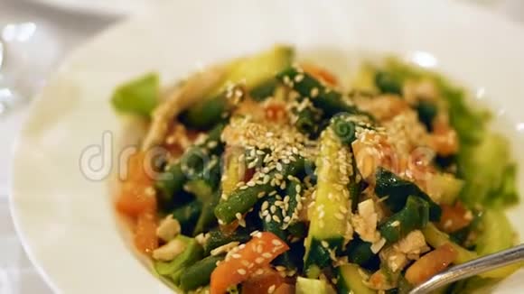 青豆沙拉红辣椒鸡肉生菜叶和芝麻特写视频的预览图