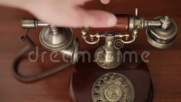合上男性手拿起老式复古电话的接收器接电话视频的预览图