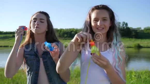 情绪激动的少女在湖边制造肥皂泡和欢笑视频的预览图