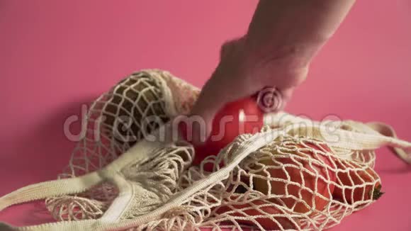 水果和蔬菜在网袋替代塑料购物袋在粉红色背景4k视频的预览图