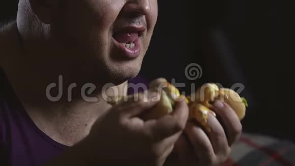 油腻的食物遍布胖子的脸丑陋凌乱的行为特写视频的预览图