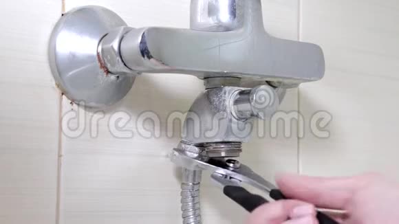 浴缸水龙头重新打开拧开漏水的淋浴软管上的螺母管道修理和DIY概念视频的预览图