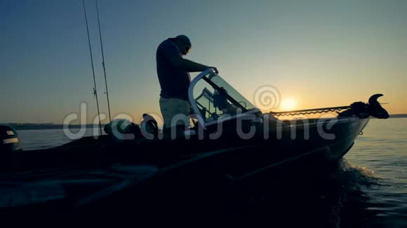 两名垂钓者正驾驶汽船在日出时钓鱼视频的预览图
