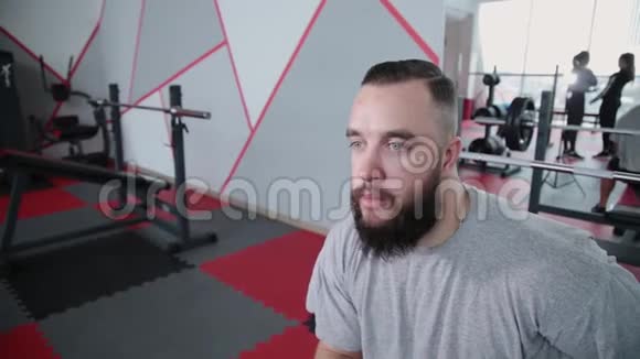 英俊的运动员躺在健身房的长凳上视频的预览图
