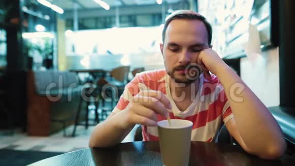 年轻悲伤的男人在城里的咖啡馆里等人视频的预览图