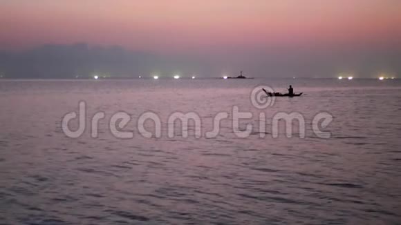 日落时分在海上渔船灯光之间的人浅顶剪影航运图片视频的预览图