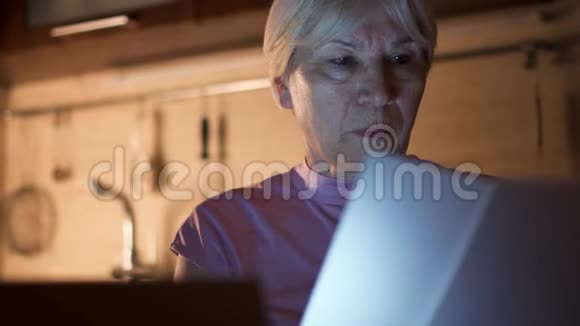 高级女性自由职业者晚上从家庭办公室使用笔记本电脑工作过度的女商人努力工作视频的预览图