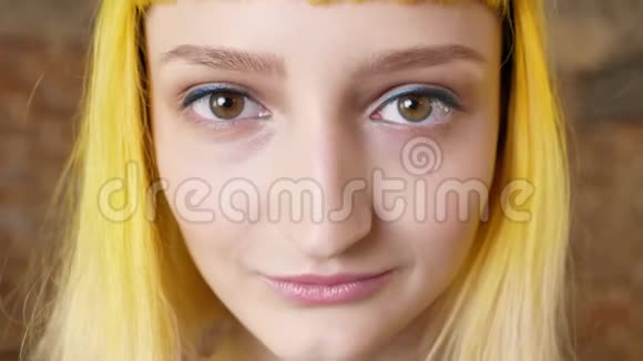 她的脸上留着黄色头发看着镜头微笑着发型异常视频的预览图