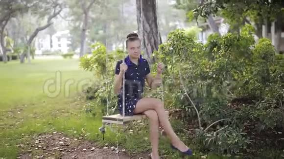 在公园里一个年轻的女孩骑着一个木秋千视频的预览图