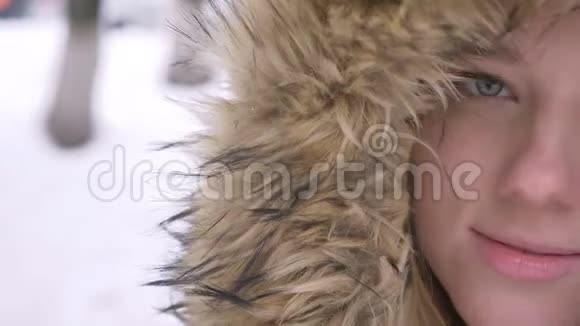 在冬天的街道上一幅美丽的年轻白种人女孩的近照她穿着毛衫漂亮地微笑着对着镜头视频的预览图
