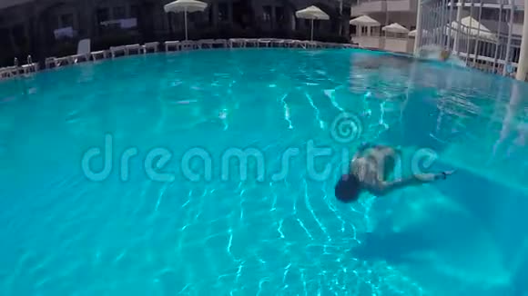 穿短裤的人在室外游泳池里水下游泳视频的预览图