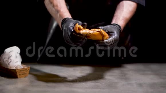 职业厨师用黑手套煮成两块美味的热煎烤奶酪包分离在黑色视频的预览图