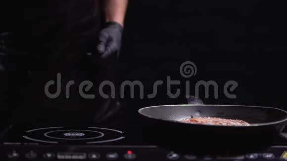 牛肉牛排躺在烤架上背景是一只雄性手戴着橡胶手套视频的预览图