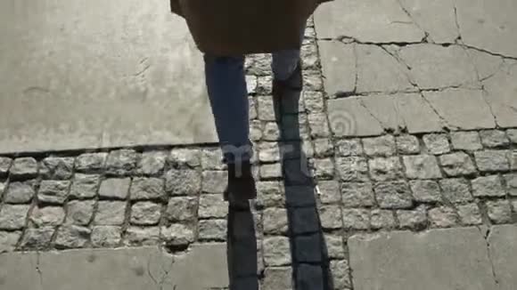 男士穿着蓝色牛仔裤棕色皮鞋和外套的双腿特写镜头视频的预览图