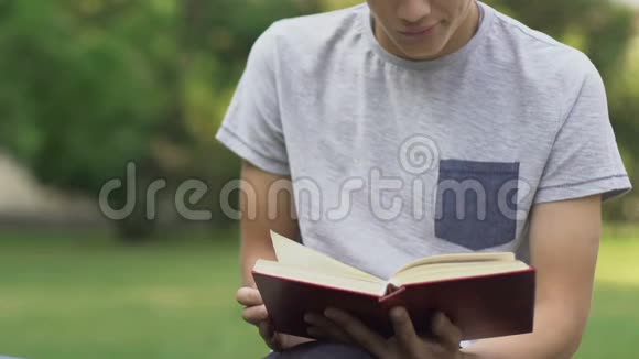 十几岁的男孩读无聊的书准备测验强迫自己学习视频的预览图