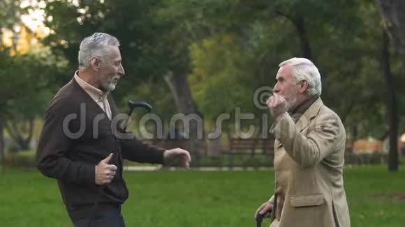 快乐的退休男子用手杖在公园跳舞一起玩幽默视频的预览图