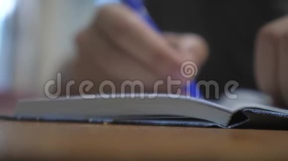 人在笔记本上写字男人生活方式手写记事本概念商业教育1男人在房间里做笔记视频的预览图
