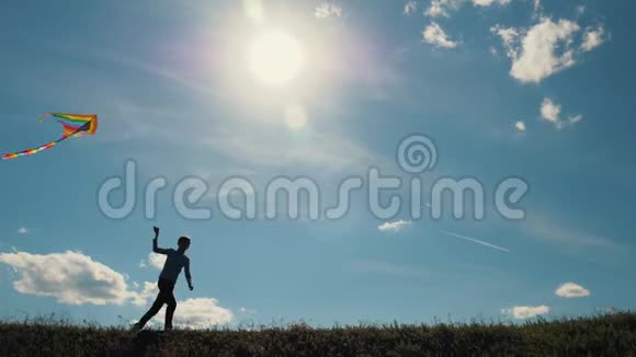 一个男孩带着风筝跑过田野梦想飞翔孩子们游戏视频的预览图