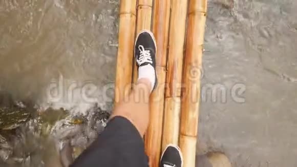 热带雨林丛林河上的小竹桥上行走的年轻旅行者从上面4K第一人称视图巴厘视频的预览图