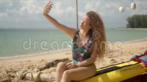 迷人的女人在海滩上自拍视频的预览图
