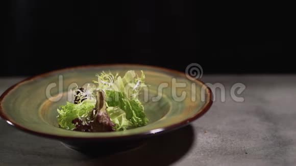 卷心菜和生菜叶子放在一个泥板上站在厨房的桌子上孤立在黑色的背景上快关门视频的预览图
