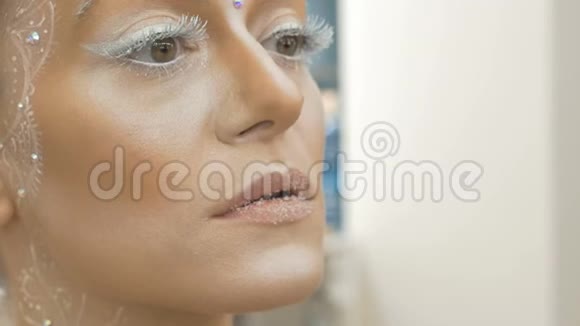 化妆师用特殊画笔画出模特的嘴唇特写视频的预览图
