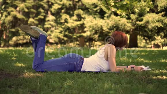 躺在公园草地上看书的女孩视频的预览图