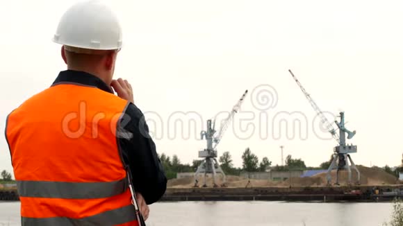 经理的头在看港口起重机提取河沙并认为工业视频的预览图
