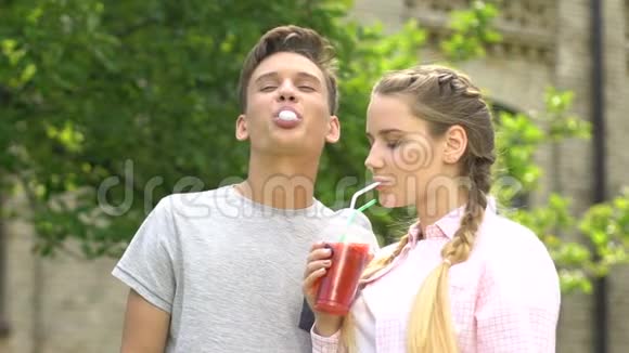 快乐的十几岁情侣一起玩嚼口香糖喝苏打水慢点视频的预览图