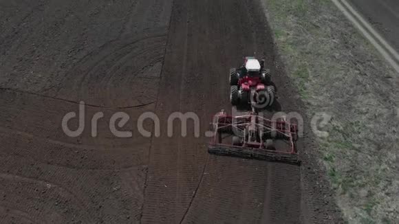 拖拉机在播种季节开始时在地上犁地一个农民站在他的铁轨上视频的预览图