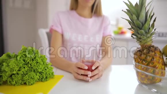 快乐的女人早晨在厨房里慢慢地喝着新鲜果汁视频的预览图