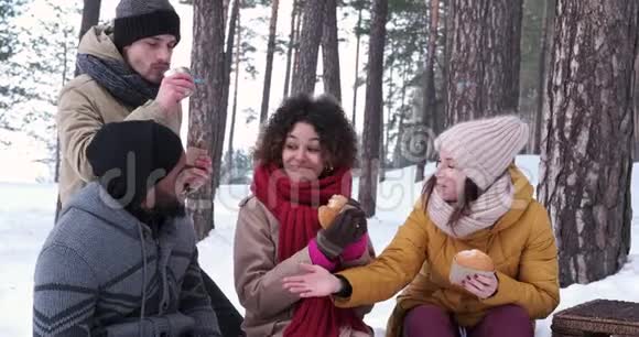 朋友们在雪地森林里野餐视频的预览图