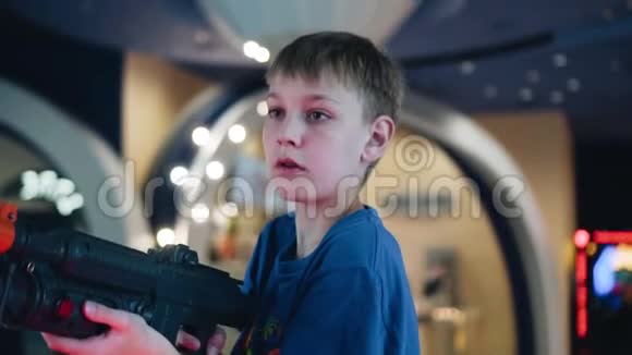 一个男孩在老虎机大厅里用玩具机特写这个男孩玩电子游戏视频的预览图