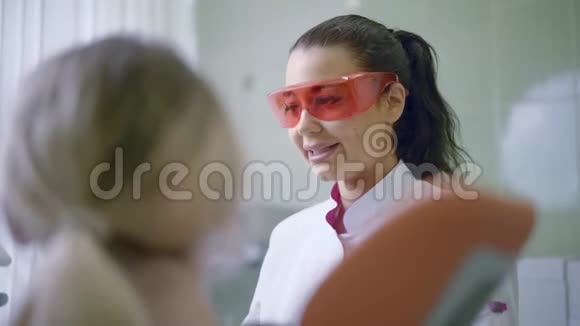 牙医在牙科诊所与病人交谈并准备治疗视频的预览图