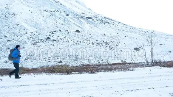 一个背着背包的人在下雪的路上旅行它沿着一个高脊视频的预览图