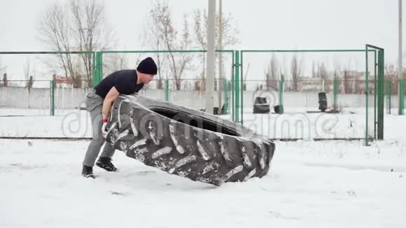 肌肉男做交叉健身运动在运动场上举起一个大橡胶轮胎视频的预览图