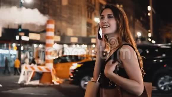 年轻快乐的女人站在纽约美国市中心的交通道路附近用手机交谈视频的预览图