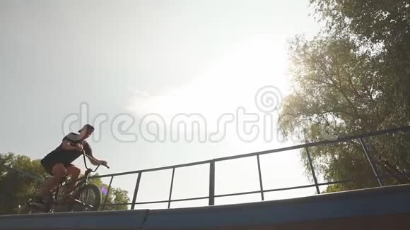 自由式在滑板公园的坡道上BMX骑手在自行车上滑行街头文化视频的预览图