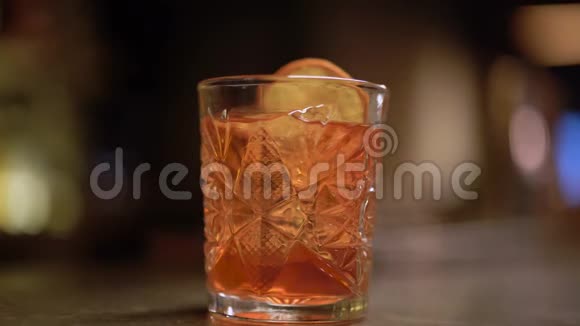 加橙和冰的酒精在桌子旁边酒保把肉桂放进杯子里视频的预览图