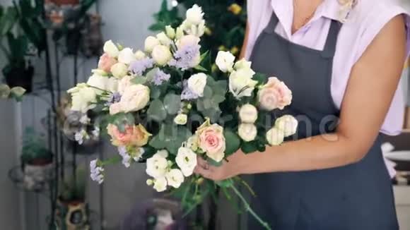 花商女人用玫瑰树叶和果蝇创造出可爱的花束视频的预览图