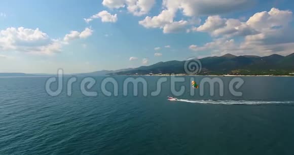 空中飞行快艇漂浮在蔚蓝的海面上通过空中牵引游客的帆伞视频的预览图